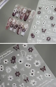 Macro detail of 5D embossed nail stickers featuring purple flowers and 3D butterfly designs