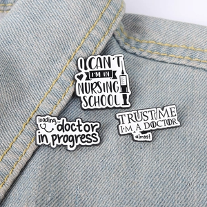 Close-up of medical enamel pins on denim, featuring syringe and stethoscope designs