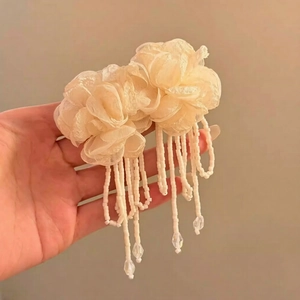Detailed macro view of beige fabric flower earrings with long beaded tassels and water drop beads