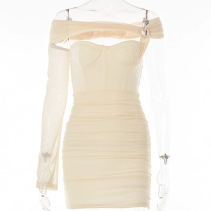 Dettaglio dell'abito aderente beige con patchwork in mesh e design arricciato sui fianchi
