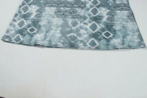 Detailed hem view of blue tie-dye printed dress with white geometric patterns