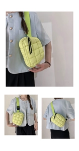 Detail of light green quilted crossbody bag with adjustable wide strap and zip cords