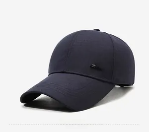 Detail view of the silver Style metal logo on a navy blue outdoor baseball cap for men