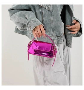 Detailed view of a mini metallic rose red handbag with shiny patent leather texture