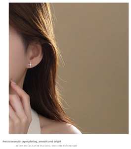 Detail shot of a sparkling s925 silver star zircon earring on a female model