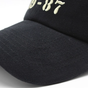Macro d'une casquette NYC avec broderie 3D beige 9-87 sur un tissu en coton noir de qualité