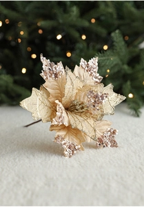 Champagne gold sequin Christmas flower ornament placed on a soft white plush rug background