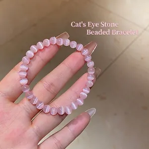 Handheld view of pink cat eye stone beaded bracelet with glossy round beads for women