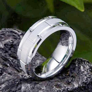 Macro shot of silver titanium steel ring with brushed center on dark natural stone