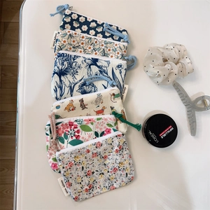 Detail view of cotton floral coin purses with zipper closure and branded side label