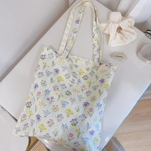 Detail of floral canvas tote bag with woven label and colorful flower patterns