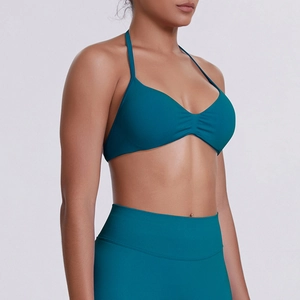 Detail of teal halter neck sports bra and high-waist yoga leggings with knit texture