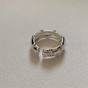 Macro view of minimalist S925 sterling silver ring with quilted pattern and stud edges