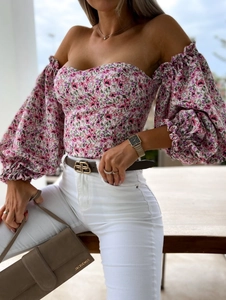 Detail of floral off-shoulder crop top with puff sleeves and cinched waist for summer