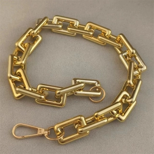 Thick gold link chain with lobster clasp on grey felt background for jewelry making