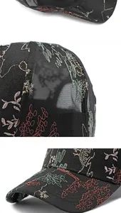 Detailed close-up of colorful floral embroidery and breathable mesh on a black baseball cap