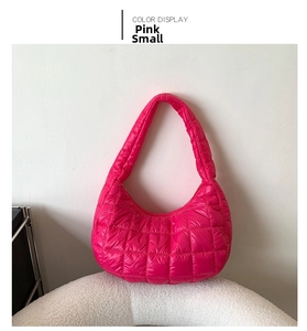Detail of small rose pink quilted tote bag with diamond stitching on fluffy white stand