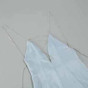 Detail of light blue satin dress featuring sparkling rhinestone chain straps and V-neckline