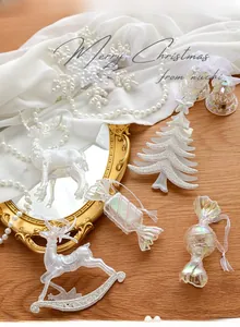 Detailed view of iridescent glitter Christmas tree and reindeer ornaments with silk ribbons