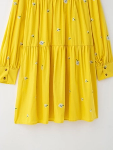 Detail of yellow French pastoral dress featuring intricate white floral embroidery