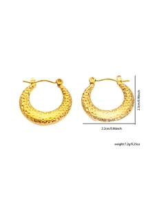 Macro view of gold-tone titanium steel hoop earrings with textured hammered finish