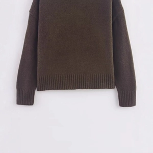 Flat lay of a vintage brown knit sweater with drop shoulder and ribbed cuffs