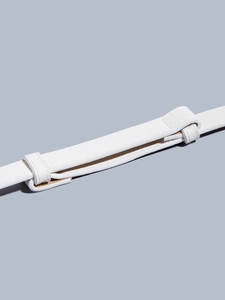 Detail of adjustable white textured leather belt with refined buckle for dresses
