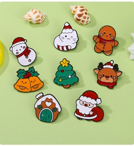 Collection of 8 festive enamel Christmas pins including Santa and snowman on green surface