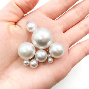 Handheld assorted sizes of white faux pearl charms with gold loops for DIY jewelry making