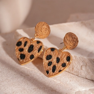 Macro view of leopard print heart pendant with golden edges and woven texture stud