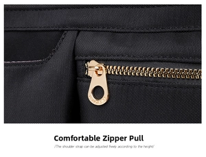 Detail shot of golden metal zipper puller on high-quality black nylon shoulder bag