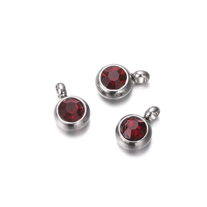 Detailed close-up of three dark red faceted zircon charms set in silver metal bases