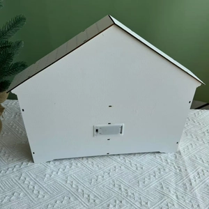 Detail of the white wooden house advent calendar back with battery box on knit blanket