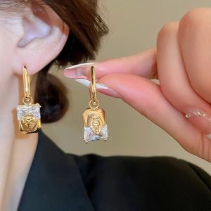 Detailed close-up of a vintage lion head earring with gold plating and crystals