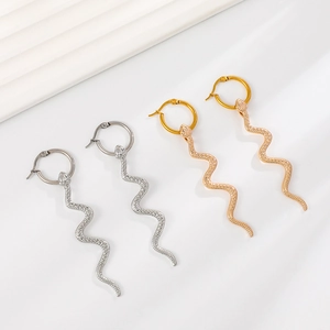 Close-up of gold and silver snake earrings with scale textures on white background
