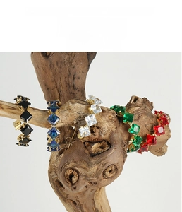 Macro view of five-color square zircon earrings set on a natural wooden branch display