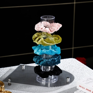 Lot de 5 chouchous en velours colorés présentés sur un support de rangement vertical transparent