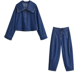 Dettaglio del set in denim blu scuro con giacca con zip e pantaloni carrot con coulisse