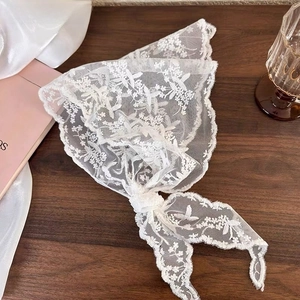 Close-up of white lace floral embroidery on vintage style triangular hair bandana