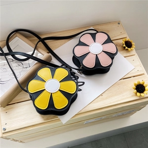 Detail of yellow and pink floral PU leather mini crossbody bags for girls on wood box