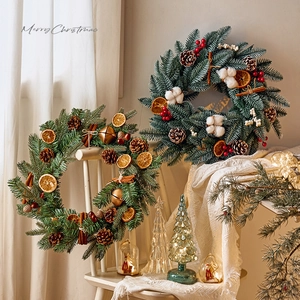 Creative Christmas wreath with pine cones, orange slices and berries for festive decor