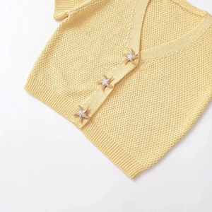 Pale yellow short sleeve knit cardigan with gold starfish shaped buttons on white background