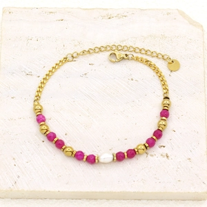 Detailed macro shot of gold-plated bracelet with freshwater pearl and pink stone beads