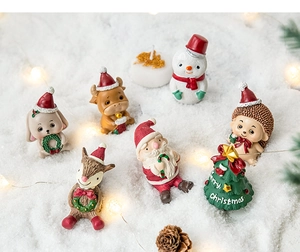 Miniature Christmas resin figurines with Santa and reindeer on artificial snow scene