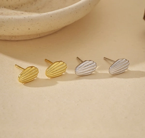 Macro detail of S925 sterling silver shell earrings with elegant vertical textures