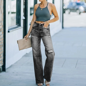 Dunkelgraue Wide-Leg-Jeans mit Rissen und dunkelgrünes Halter-Top auf moderner Straße