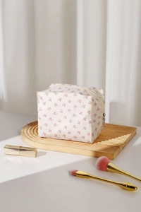 Détail de la trousse à maquillage fleurie avec fermeture éclair sur plateau