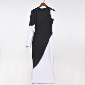Détail de la robe asymétrique bicolore avec bordure métallique argentée et coupe moulante