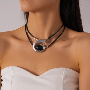 Détail du pendentif spirale argenté avec pierre noire sur tour de cou double couche