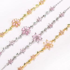 Detailed close-up of cherry blossom bracelets with pink crystals and green gem leaves